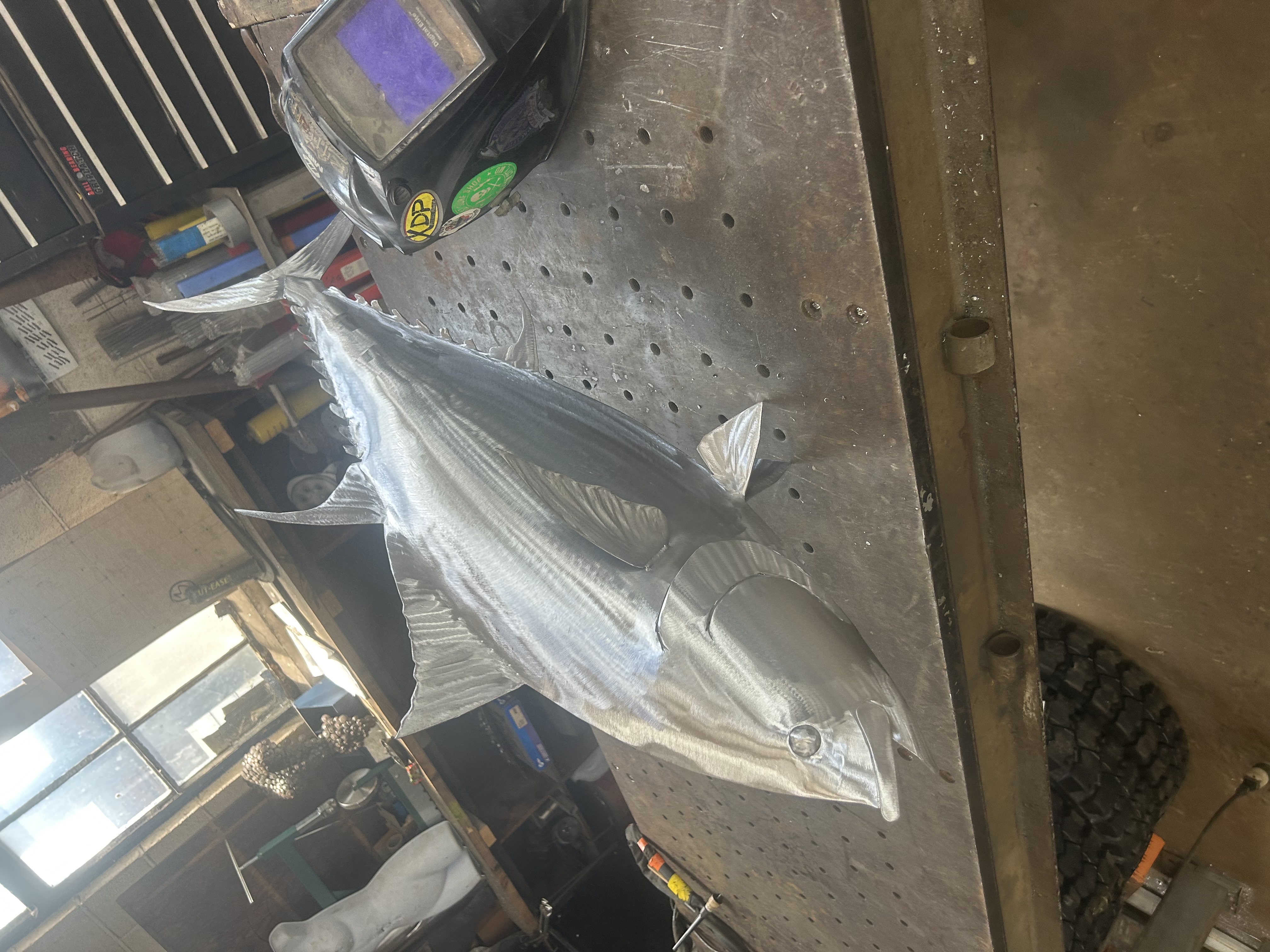 Aluminum tuna sculpture laid out on a work table
